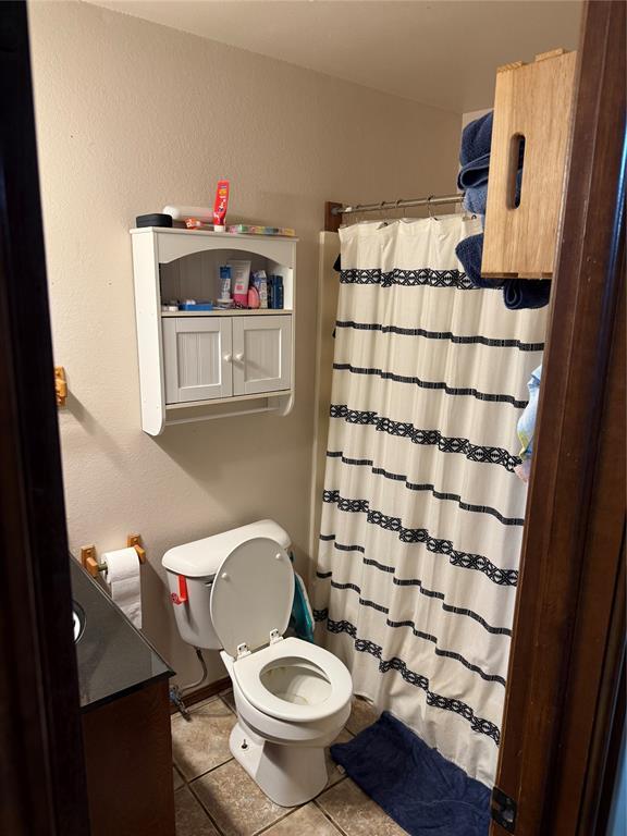 bathroom featuring vanity, a shower with curtain, tile patterned floors, and toilet