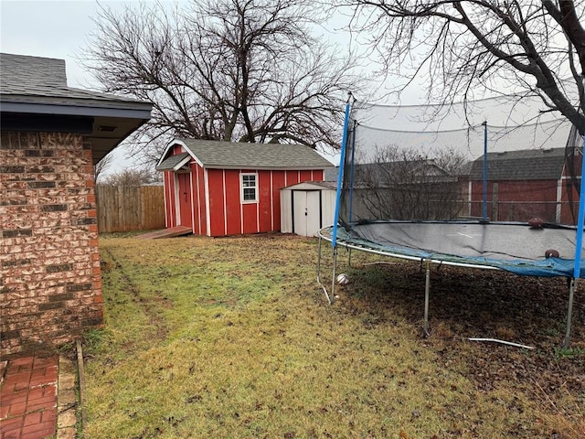 view of yard featuring a storage unit and a trampoline