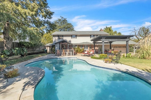 view of pool with exterior bar, a pergola, and a patio area