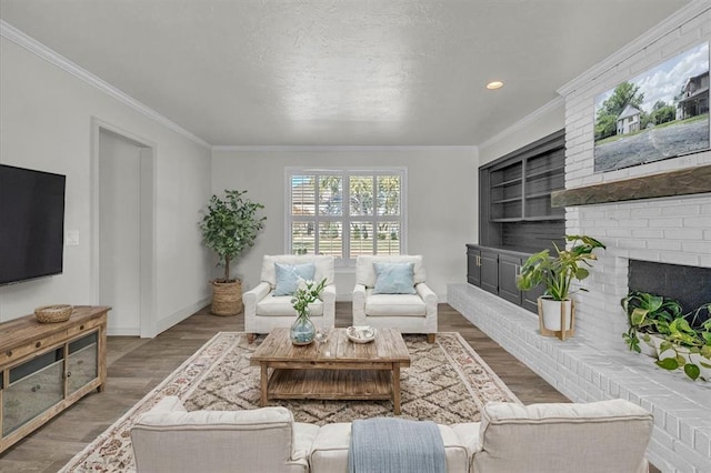 living room with hardwood / wood-style floors, crown molding, and a fireplace