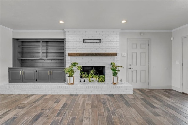 unfurnished living room with ornamental molding and hardwood / wood-style floors