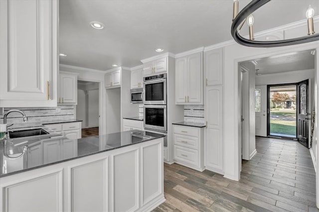 kitchen with crown molding, stainless steel appliances, sink, and white cabinets