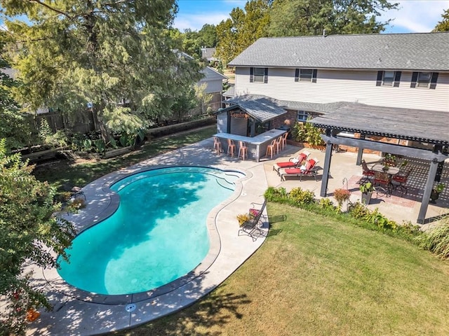 view of swimming pool featuring a patio, exterior bar, a yard, and a pergola