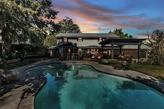 pool at dusk featuring a patio area and a pergola