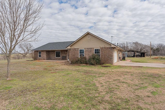 view of front of house featuring a garage, driveway, brick siding, and a front yard