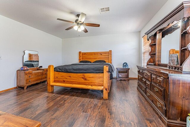 bedroom with visible vents, baseboards, ceiling fan, and dark wood-type flooring