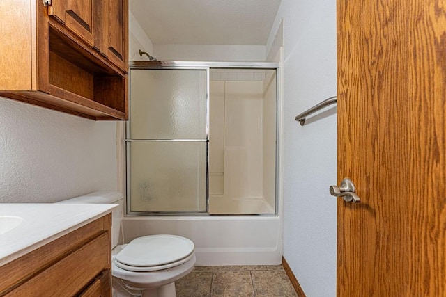 full bathroom featuring bath / shower combo with glass door, toilet, vanity, baseboards, and tile patterned floors