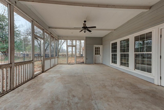 unfurnished sunroom with ceiling fan and beam ceiling