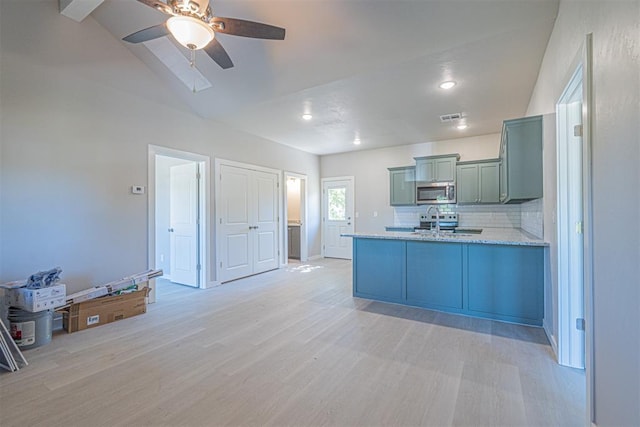 kitchen with tasteful backsplash, kitchen peninsula, ceiling fan, light stone countertops, and light hardwood / wood-style floors