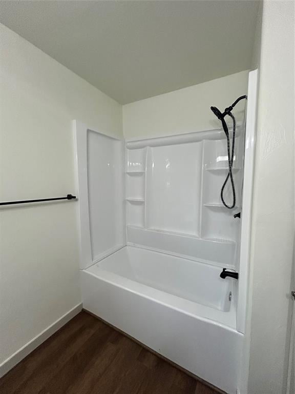 bathroom featuring wood-type flooring and tub / shower combination