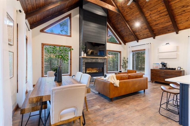 living room with beamed ceiling, high vaulted ceiling, light hardwood / wood-style flooring, and wooden ceiling