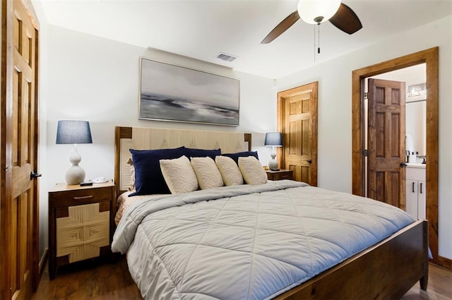 bedroom featuring ceiling fan, ensuite bath, and dark hardwood / wood-style flooring