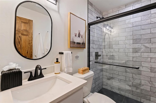 bathroom featuring vanity, toilet, and a shower with door