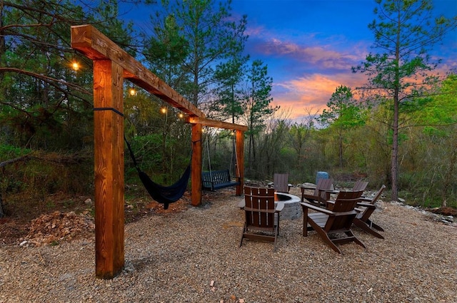 patio terrace at dusk featuring an outdoor fire pit