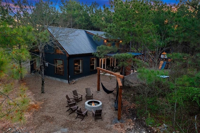 back house at dusk with an outdoor fire pit