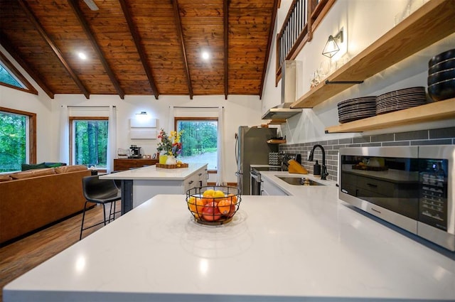 1194 Camp Ranch Rd, Broken Bow, OK 74728 - kitchen with stainless steel microwave, wooden ceiling, a kitchen island, a sink, and light countertops