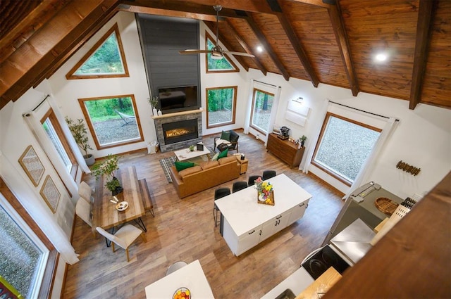 1194 Camp Ranch Rd, Broken Bow, OK 74728 - living room with wood ceiling, wood finished floors, beamed ceiling, a glass covered fireplace, and high vaulted ceiling