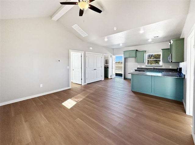 kitchen with lofted ceiling with beams, dark hardwood / wood-style floors, green cabinets, and ceiling fan