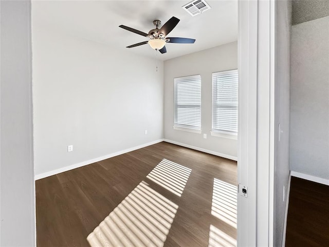 empty room featuring dark wood-type flooring and ceiling fan