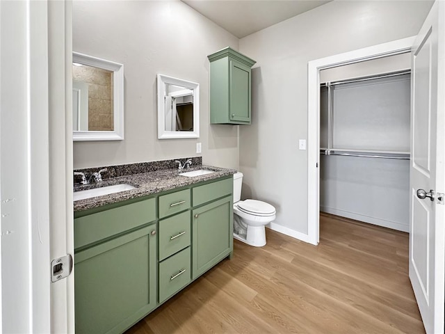 bathroom with hardwood / wood-style flooring, vanity, and toilet