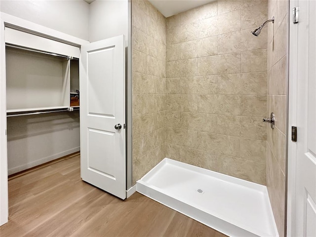 bathroom with wood-type flooring and tiled shower