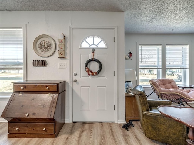 entryway featuring a textured ceiling and light hardwood / wood-style floors