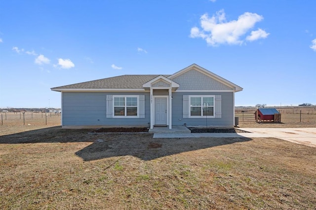 view of front of home with a rural view, central AC, and a front yard