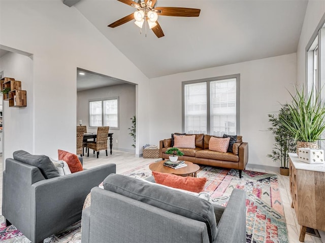 living room with high vaulted ceiling, ceiling fan, and light wood-type flooring