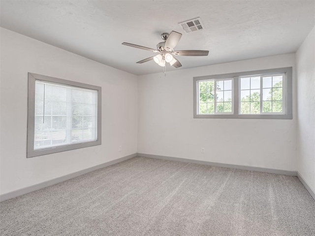 spare room featuring ceiling fan and carpet flooring