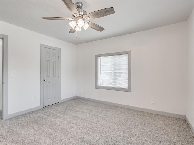 carpeted spare room with ceiling fan