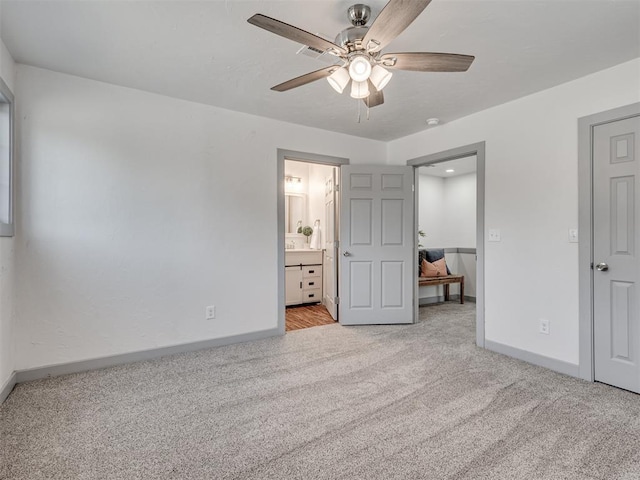 unfurnished bedroom featuring connected bathroom, light carpet, and ceiling fan