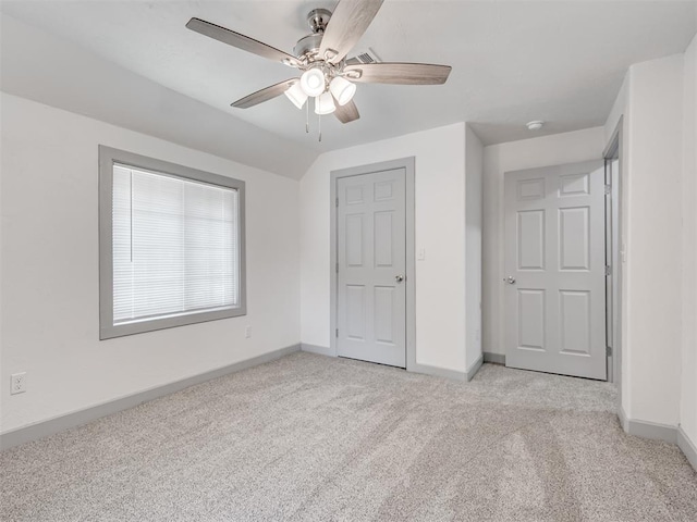 unfurnished bedroom featuring ceiling fan, light colored carpet, and vaulted ceiling