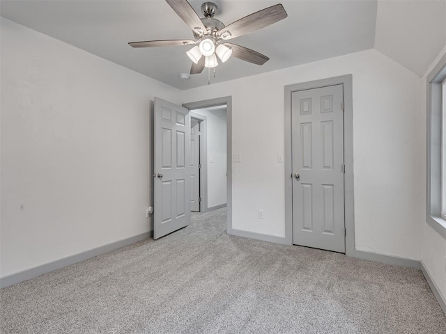 unfurnished bedroom with ceiling fan, lofted ceiling, and light carpet