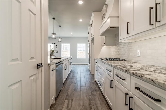 kitchen with sink, white cabinetry, tasteful backsplash, appliances with stainless steel finishes, and light stone countertops