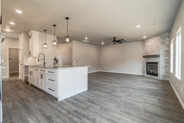 kitchen featuring white cabinetry, light stone countertops, sink, and decorative light fixtures