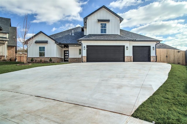 modern farmhouse with driveway, fence, a front lawn, and roof with shingles