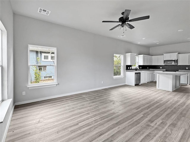 unfurnished living room with ceiling fan, sink, and light hardwood / wood-style floors