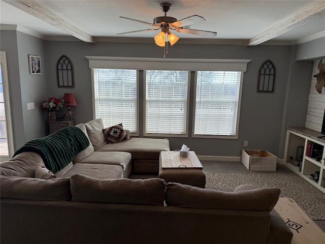 living area featuring carpet, ceiling fan, beam ceiling, and plenty of natural light