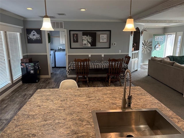 dining space featuring washing machine and dryer, visible vents, crown molding, and baseboards