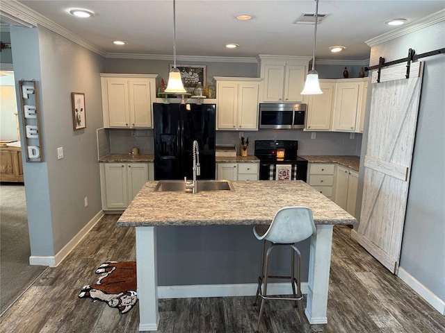 kitchen with an island with sink, visible vents, a sink, baseboards, and black appliances