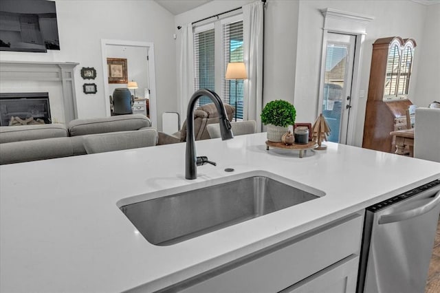 kitchen featuring vaulted ceiling, sink, and stainless steel dishwasher