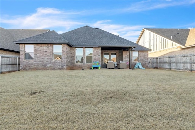 rear view of house with outdoor lounge area and a yard