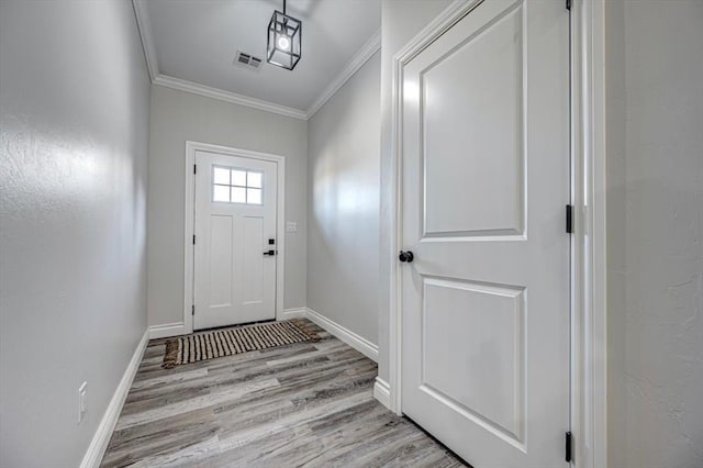 doorway featuring crown molding and light hardwood / wood-style floors