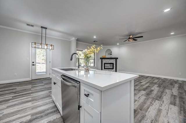 kitchen with white cabinetry, stainless steel dishwasher, sink, and a center island with sink