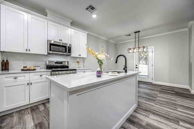 kitchen featuring sink, stainless steel appliances, an island with sink, and white cabinets