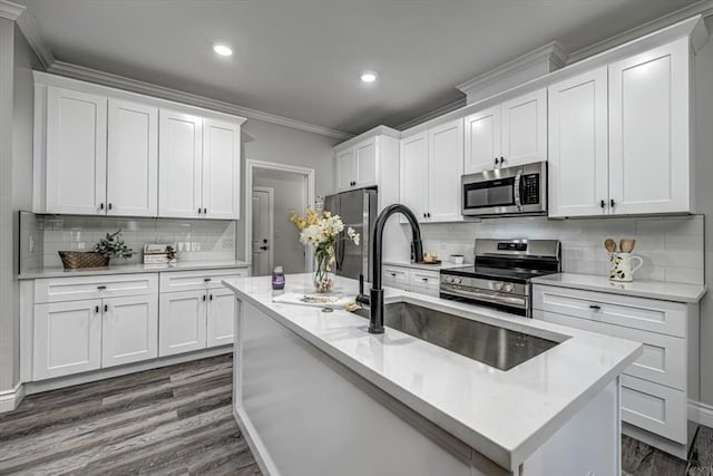 kitchen featuring stainless steel appliances, white cabinets, and a center island with sink