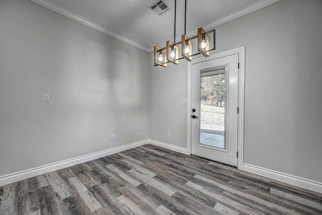 interior space with hardwood / wood-style flooring, ornamental molding, and an inviting chandelier