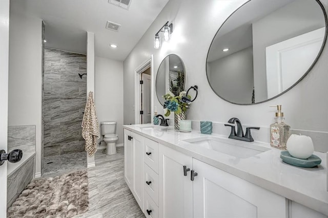 bathroom with vanity, toilet, and a tile shower