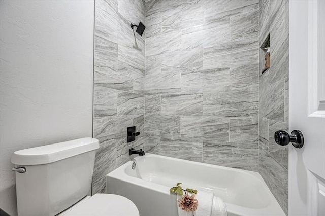 bathroom with tiled shower / bath combo and toilet