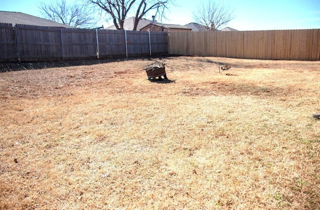 view of yard with an outdoor fire pit and a fenced backyard